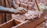 Person making bricks from clay